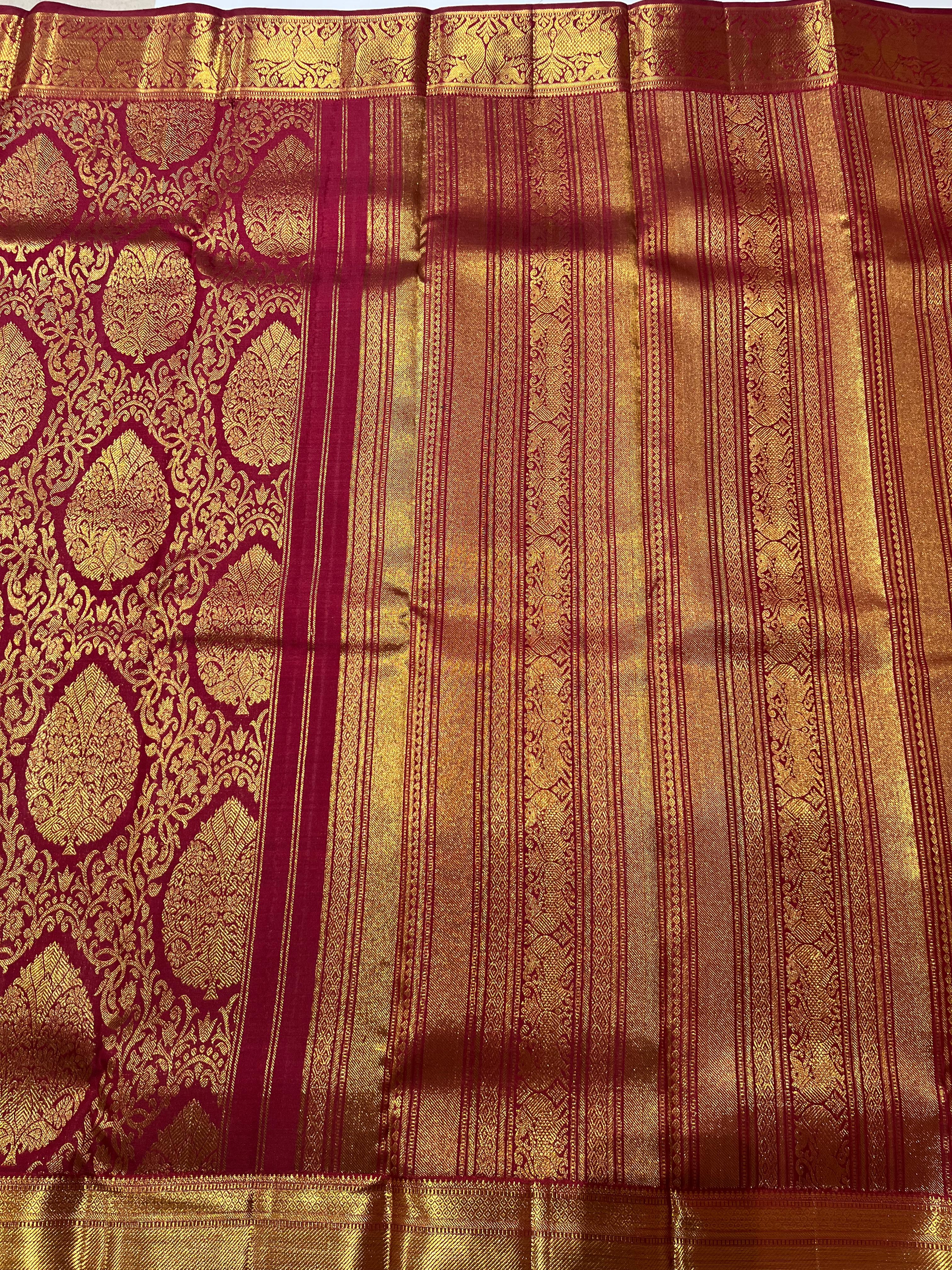 Intricate floral work on maroon and golden Kanjeevaram silk saree