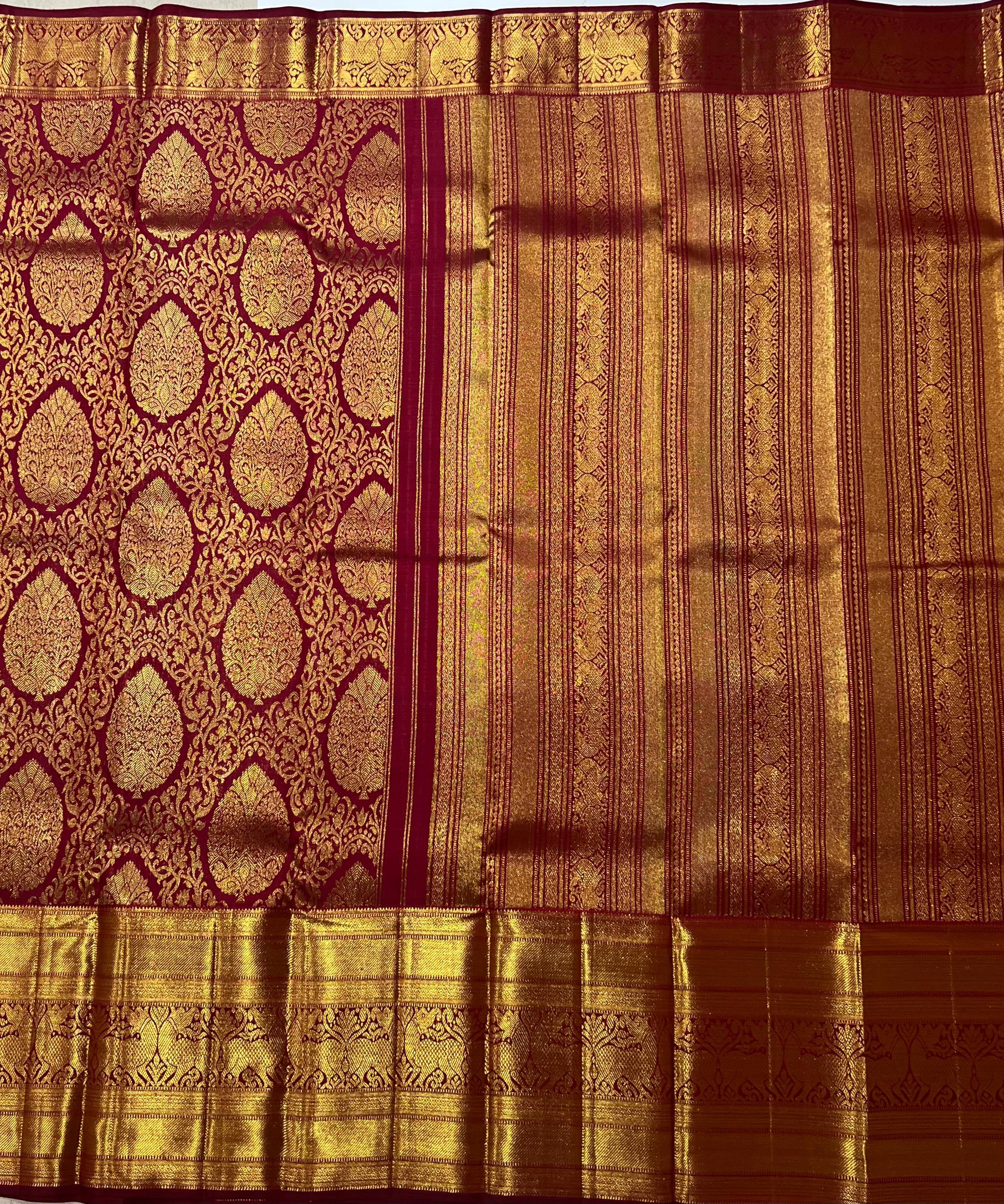 Intricate floral work on maroon and golden Kanjeevaram silk saree