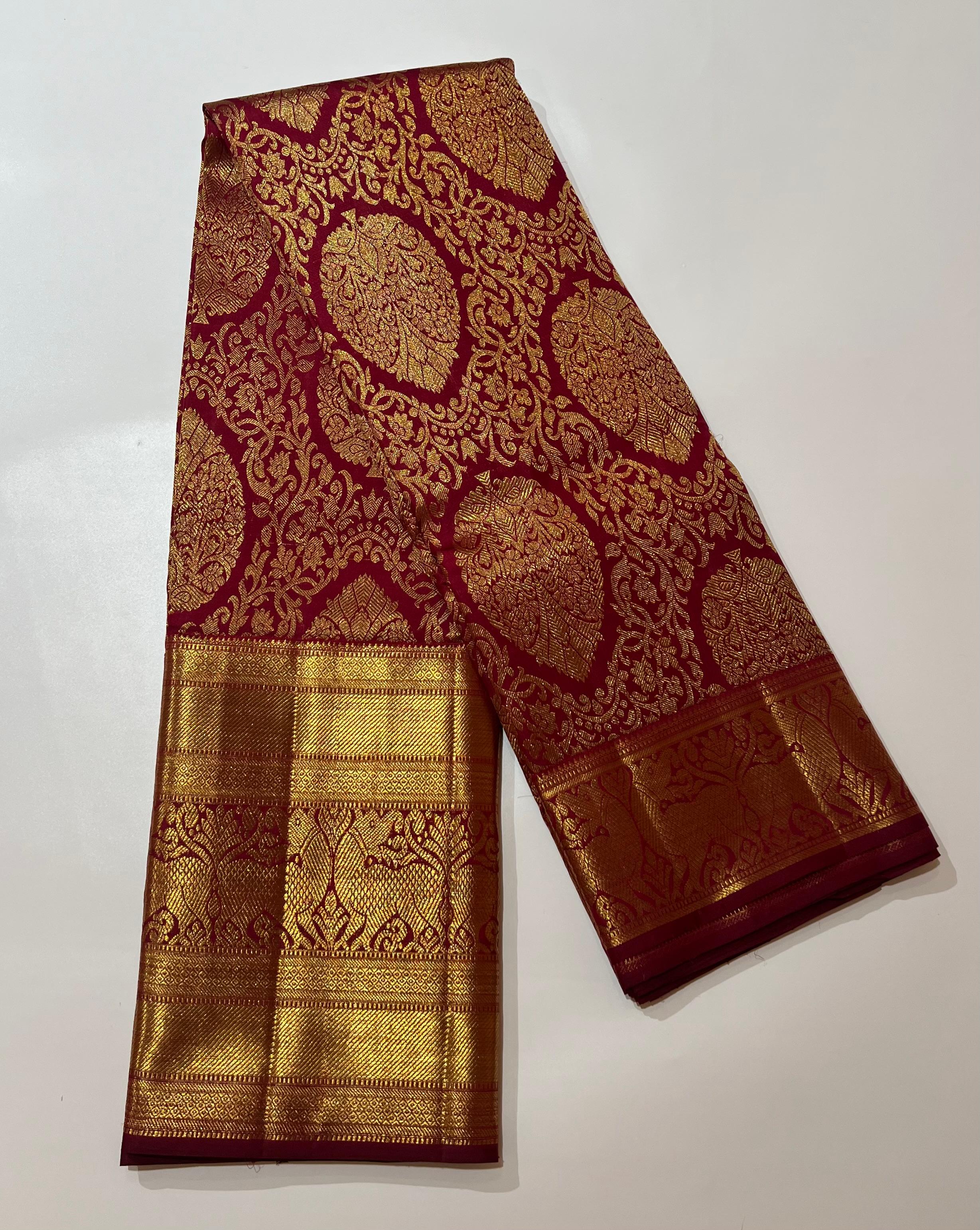 Intricate floral work on maroon and golden Kanjeevaram silk saree